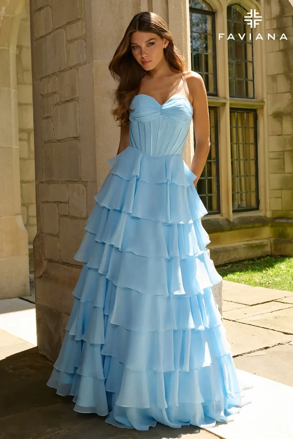 model is wearing a light blue prom dress with a tiered skirt