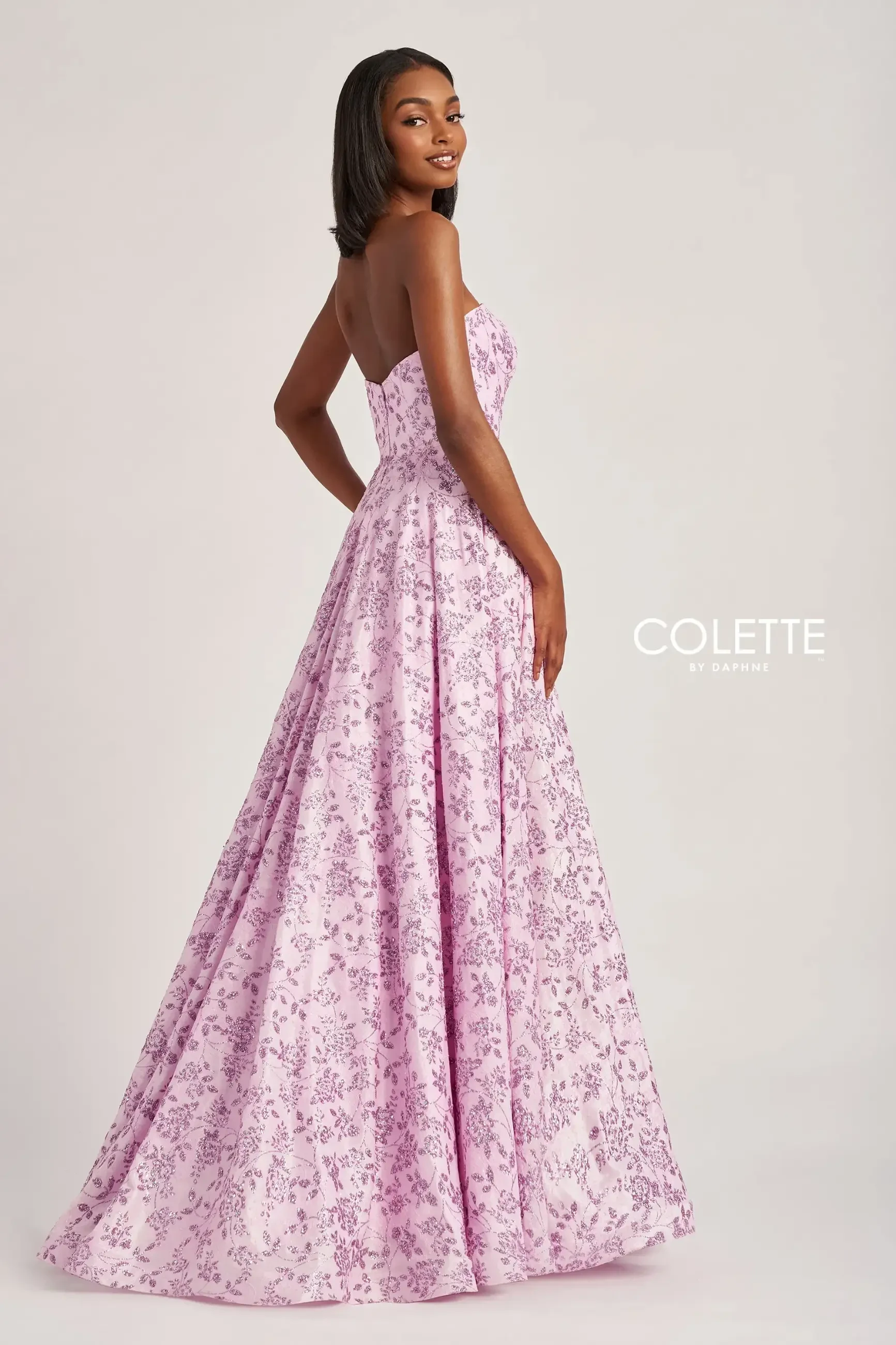 model is wearing a light pink strapless a-line prom dress