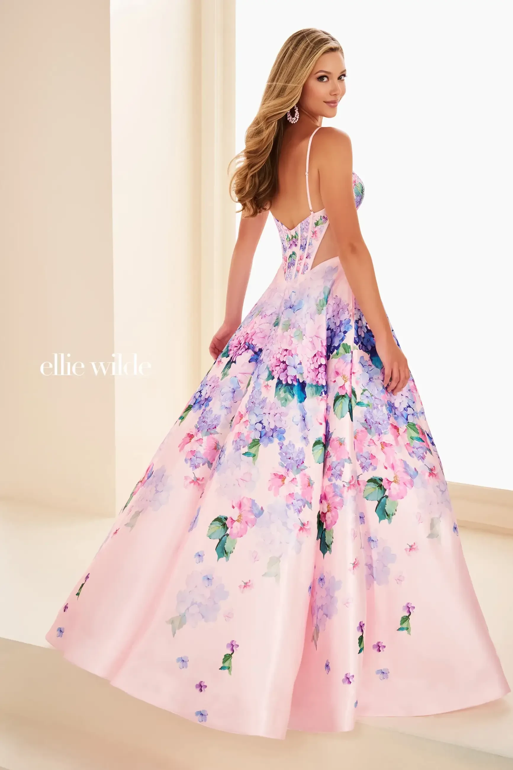 model is wearing a light pink floral prom dress