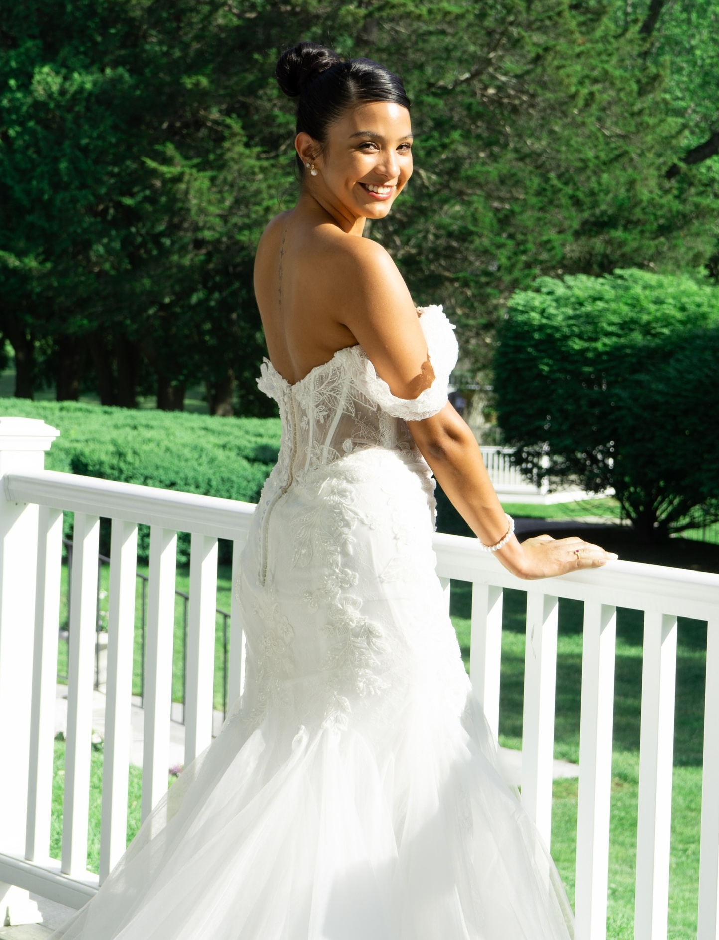 Model wearing Bridal dress leaning next to a rail