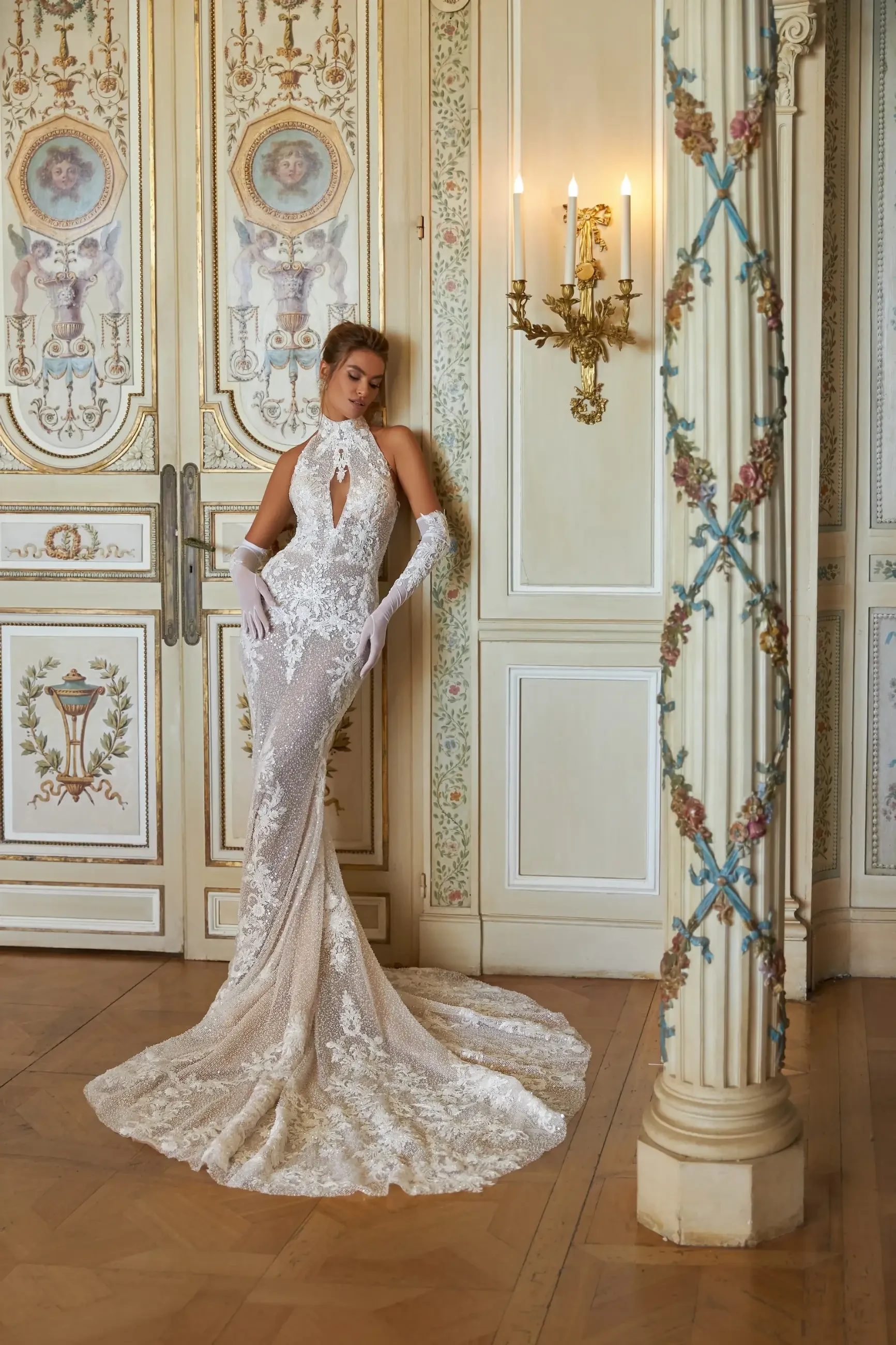 model is wearing a high neckline lace wedding dress with gloves 