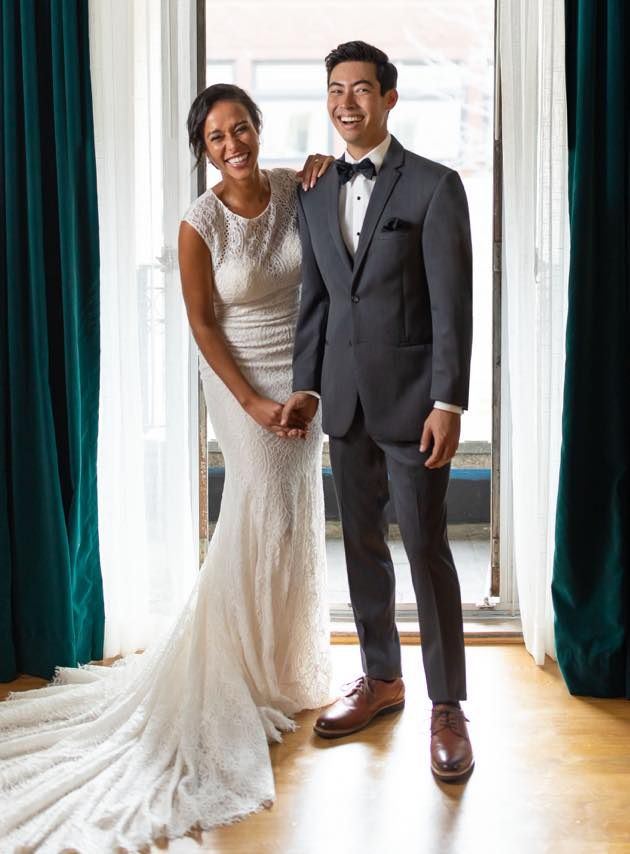 Groom in grey tuxedo and bride in white dress